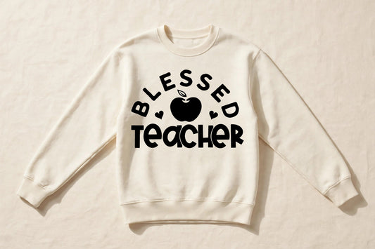 Blessed Teacher cream crewneck sweatshirt laid flat with black apple chest print