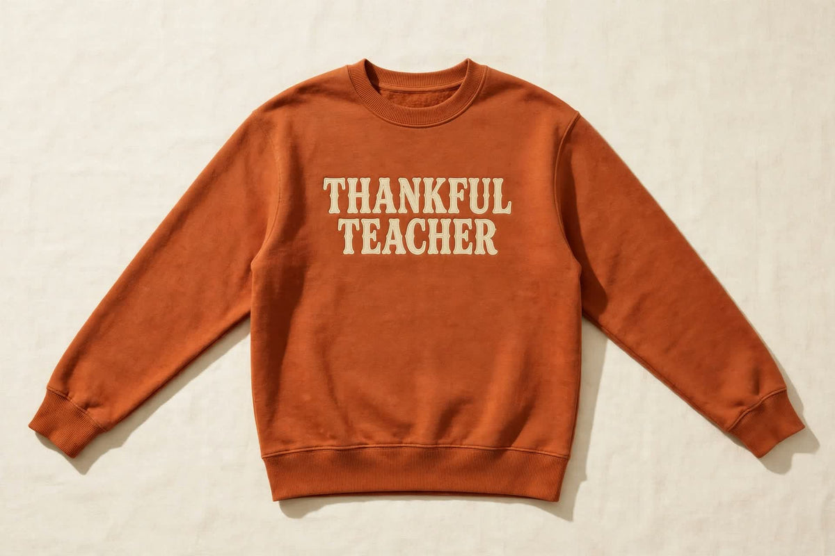 THANKFUL TEACHER sweatshirt laid flat, rust with cream retro letters